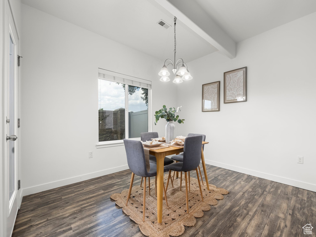 Dining space with beamed ceiling, dark wood-style floors, and a chandelier