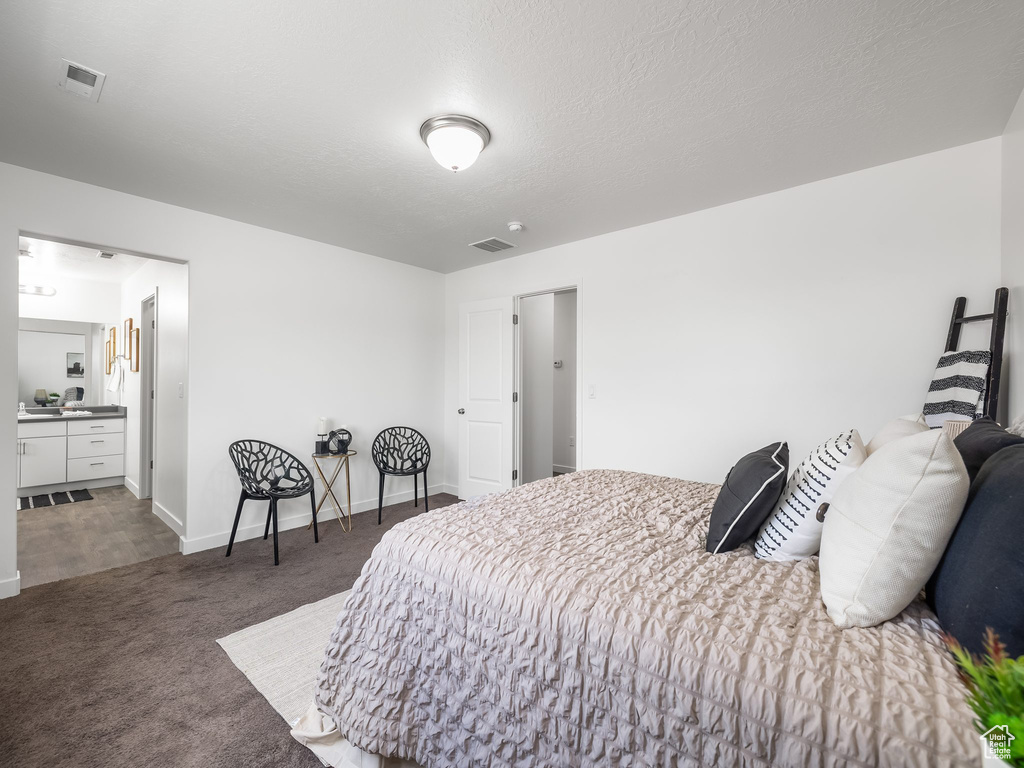 Bedroom with carpet floors and connected bathroom