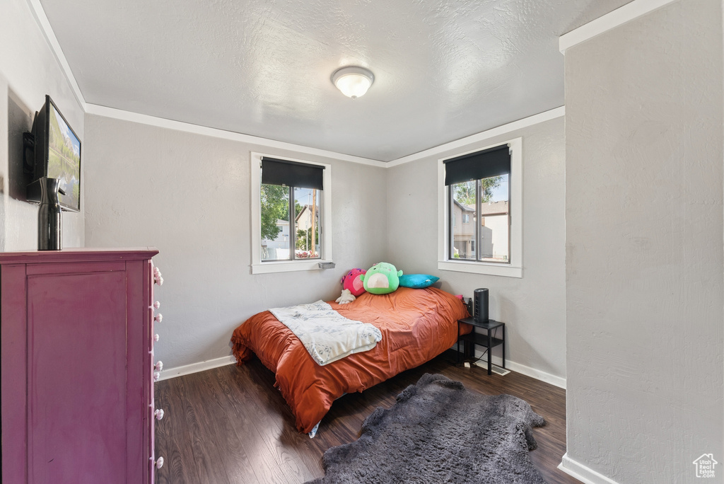 Bedroom featuring crown molding and wood finished floors