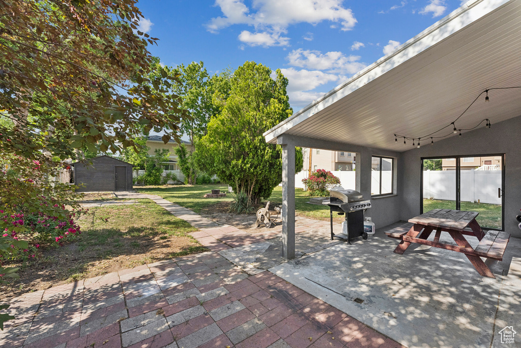 View of patio featuring grilling area and a storage shed