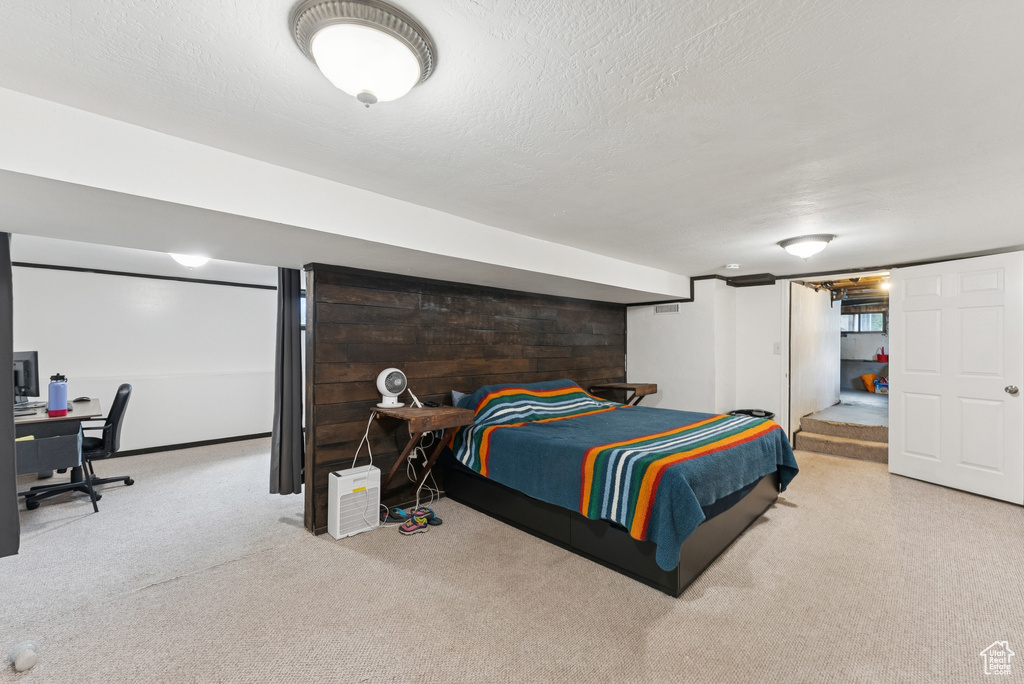 Carpeted bedroom featuring a desk and a textured ceiling
