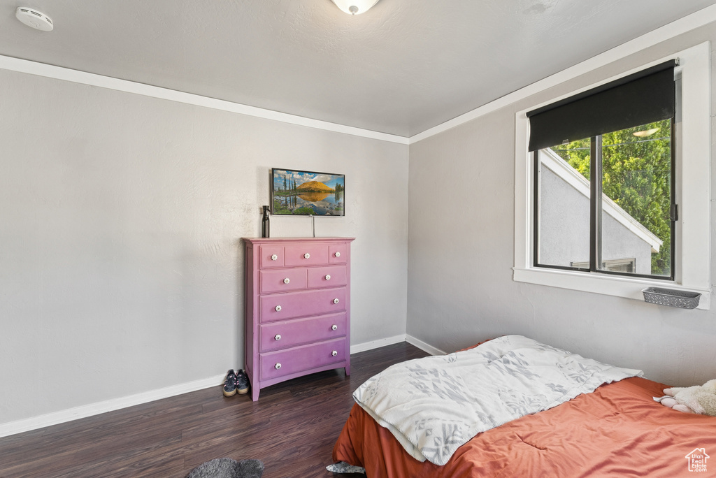 Bedroom with dark wood-type flooring and ornamental molding