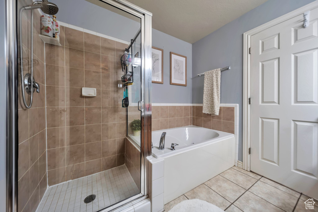 Full bathroom featuring a stall shower, tile patterned floors, and a garden tub