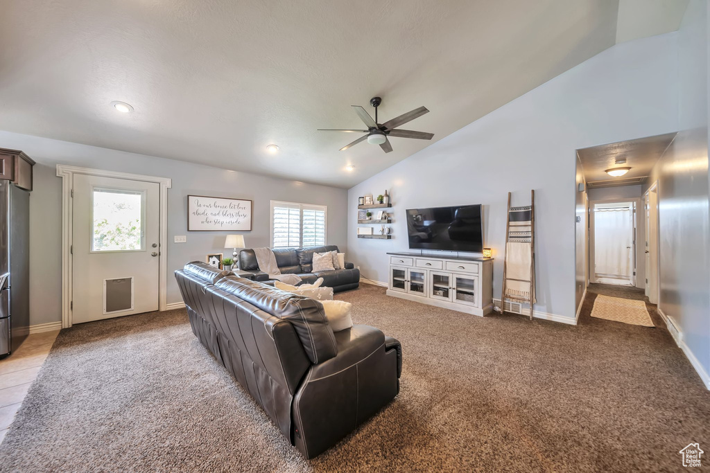 Living area with a ceiling fan, carpet, and high vaulted ceiling