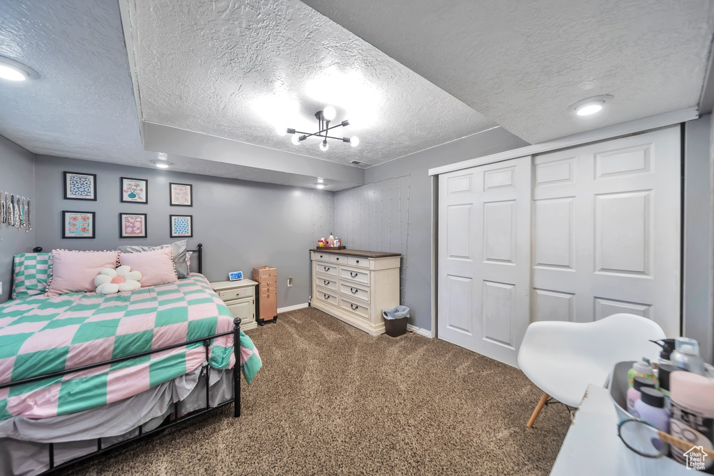 Bedroom featuring a textured ceiling, carpet, and a closet