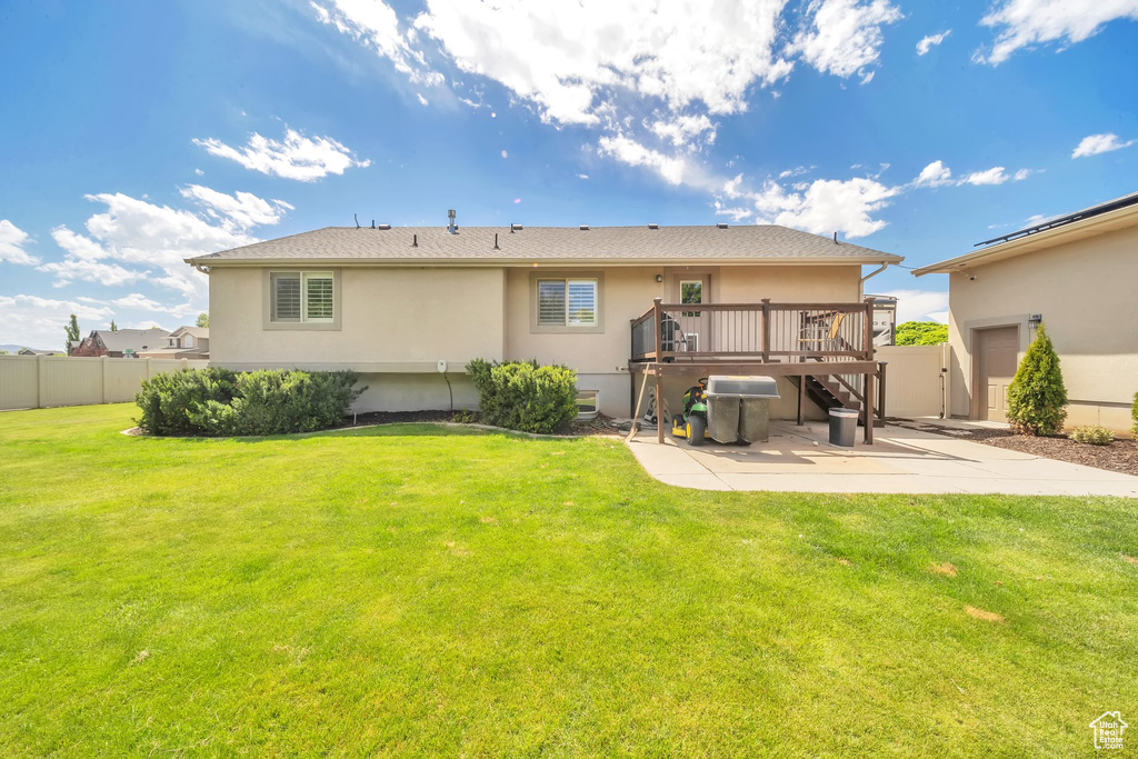 Rear view of house with a patio area, stucco siding, a wooden deck, and stairs