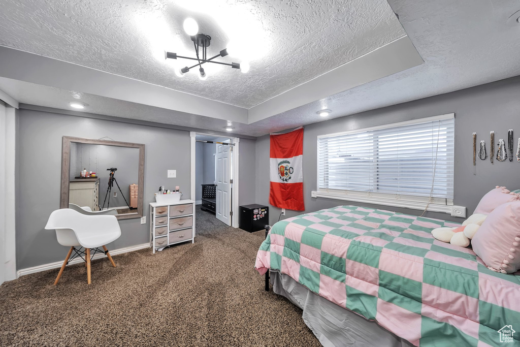 Carpeted bedroom featuring a textured ceiling and a closet