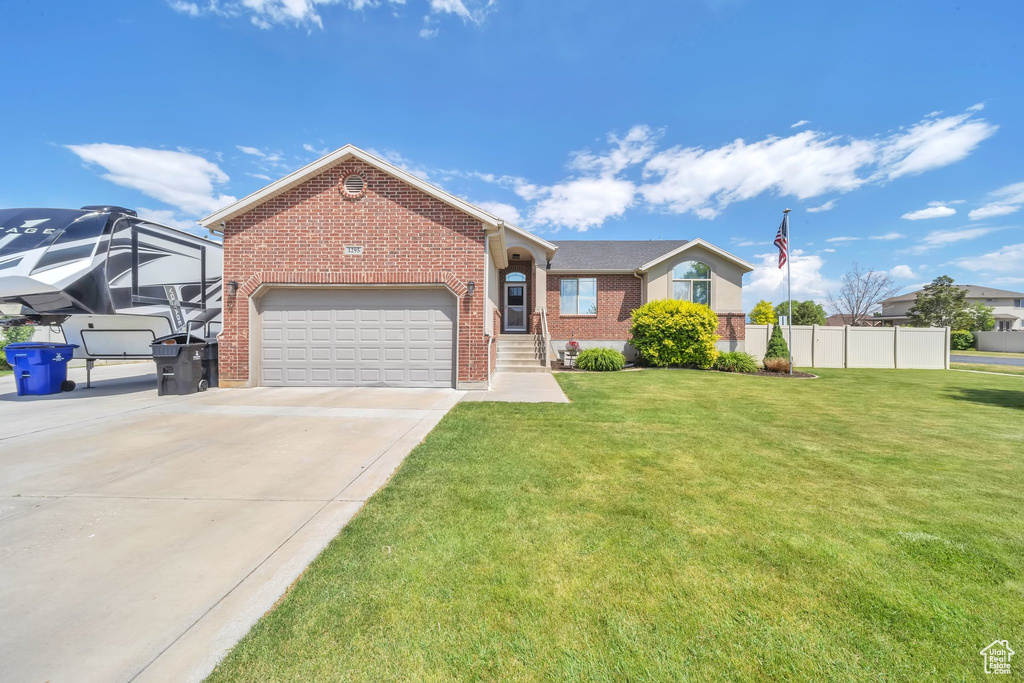 View of front of property featuring brick siding, driveway, and a garage