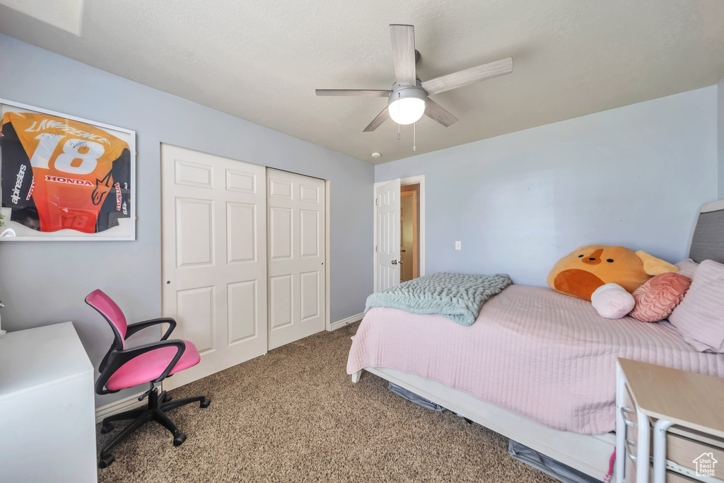Bedroom with carpet floors, a closet, and a ceiling fan