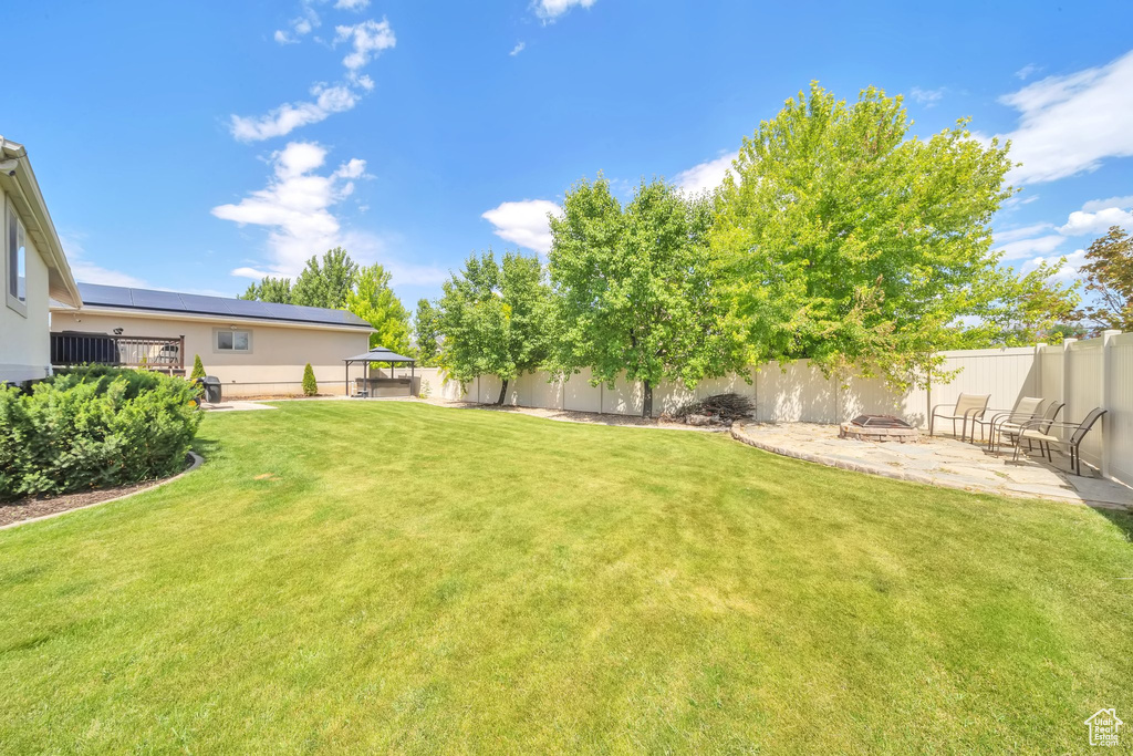 Fenced backyard with a fire pit and a patio
