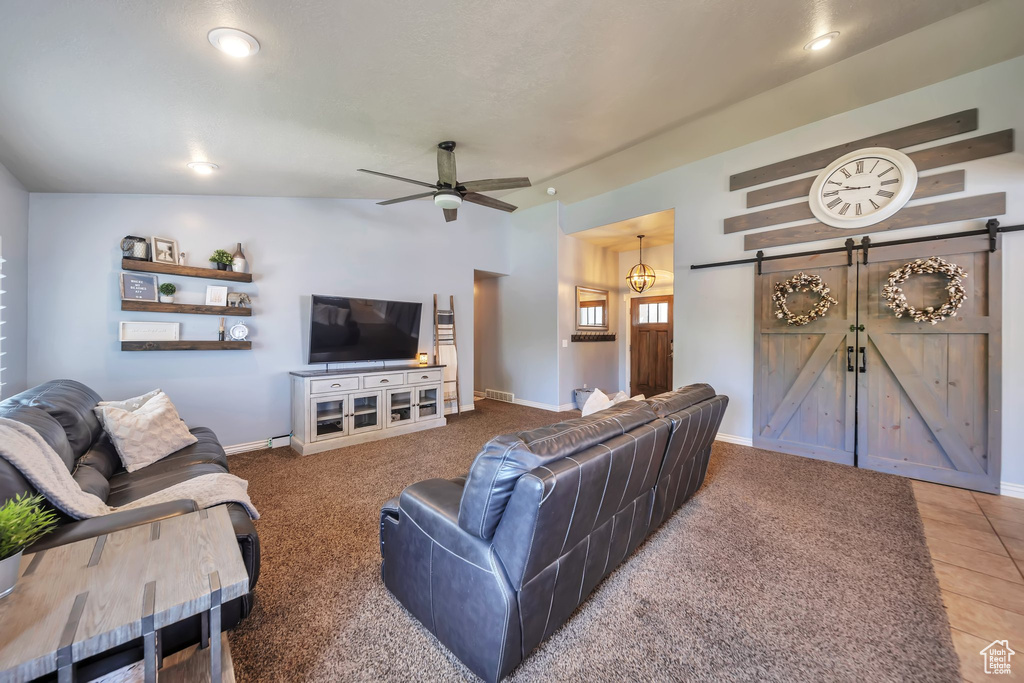 Living room featuring a barn door, a ceiling fan, and recessed lighting