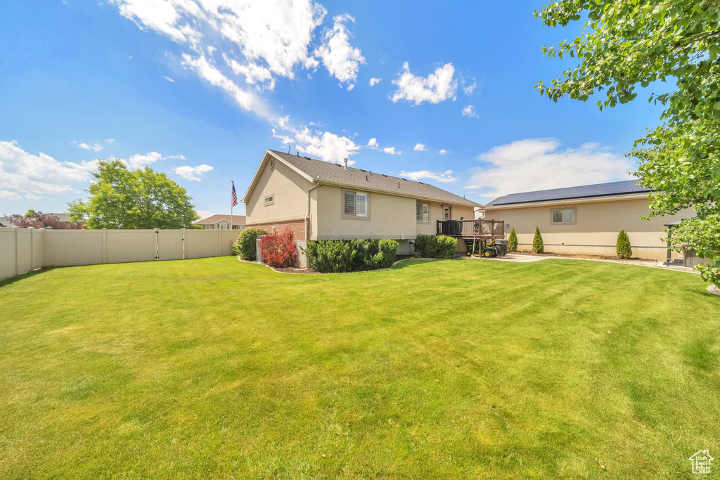 Back of house featuring a fenced backyard, stucco siding, and a deck