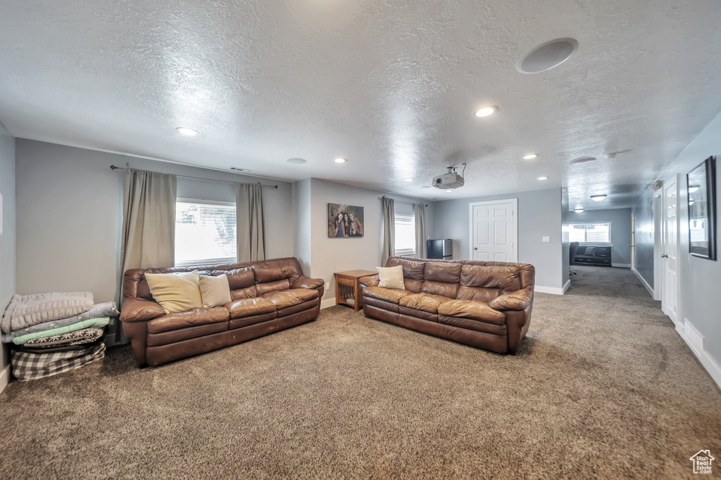 Carpeted living room featuring a textured ceiling and recessed lighting