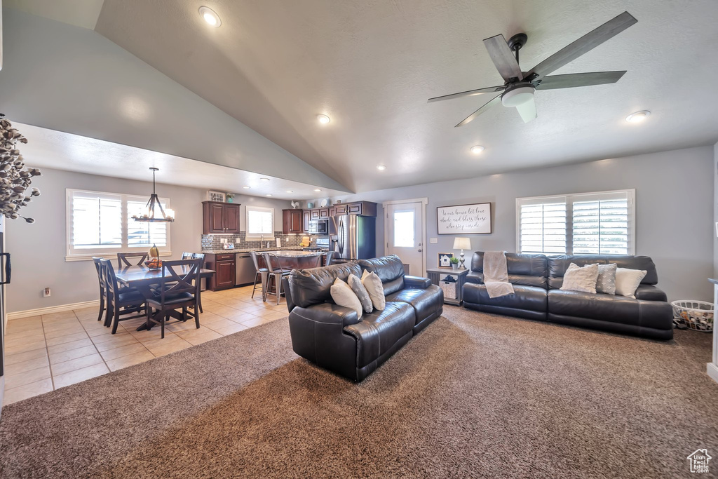 Living area with vaulted ceiling, light tile patterned floors, recessed lighting, light carpet, and plenty of natural light