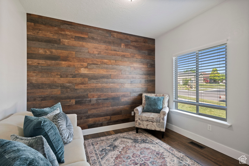Living area with wood walls and dark wood-style flooring