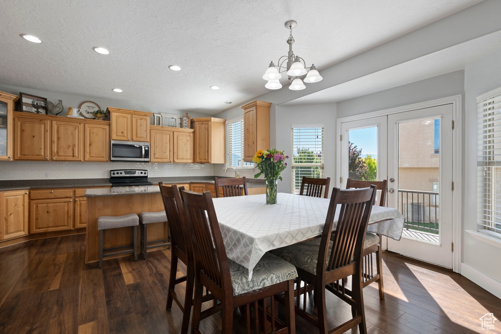 Dining area with dark wood-style floors, recessed lighting, a chandelier, and french doors