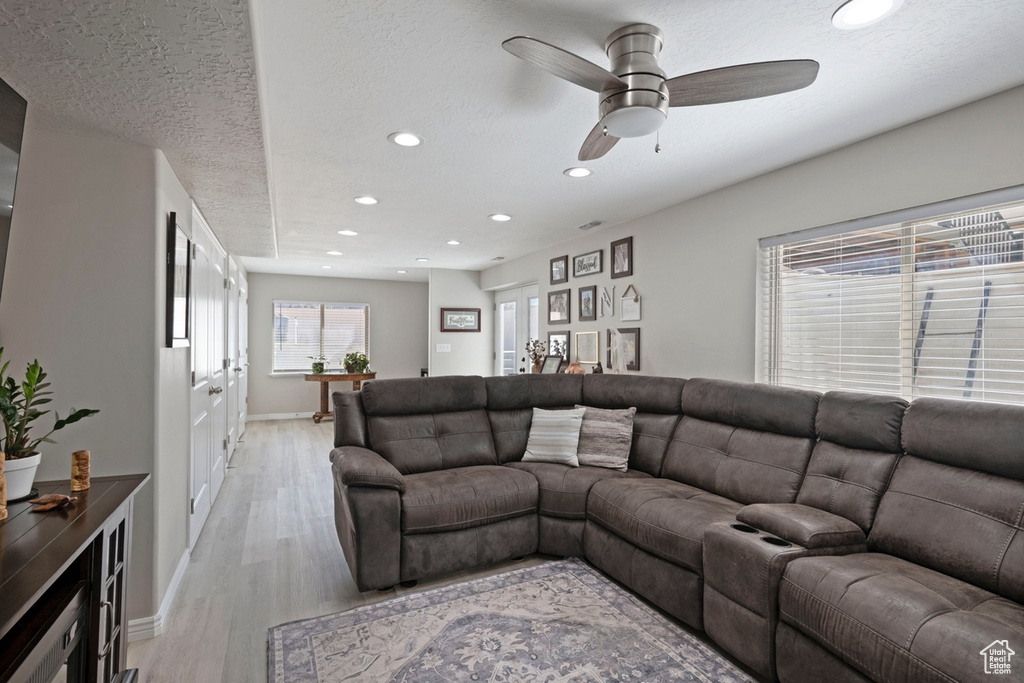 Living area with recessed lighting, light wood-style floors, and a ceiling fan