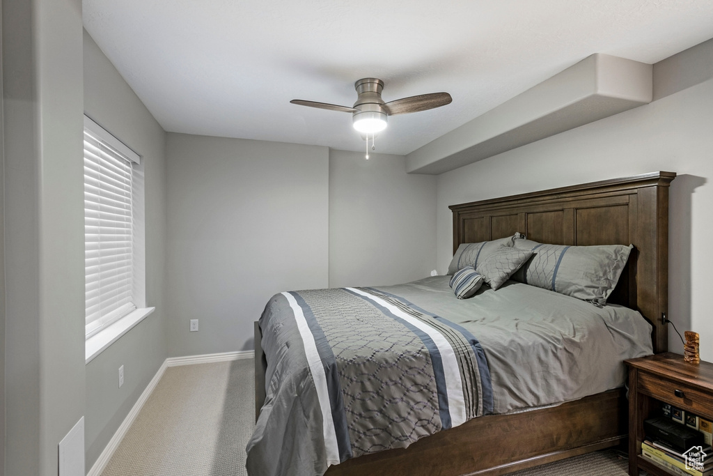 Bedroom with carpet floors, multiple windows, and ceiling fan