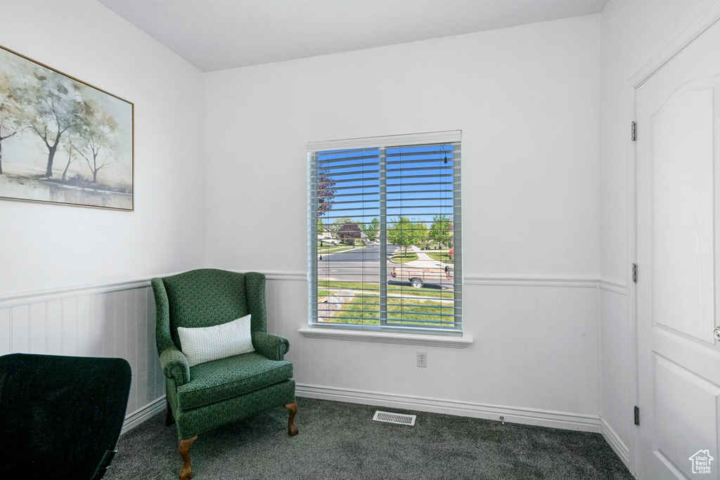 Living area featuring a wainscoted wall and carpet floors