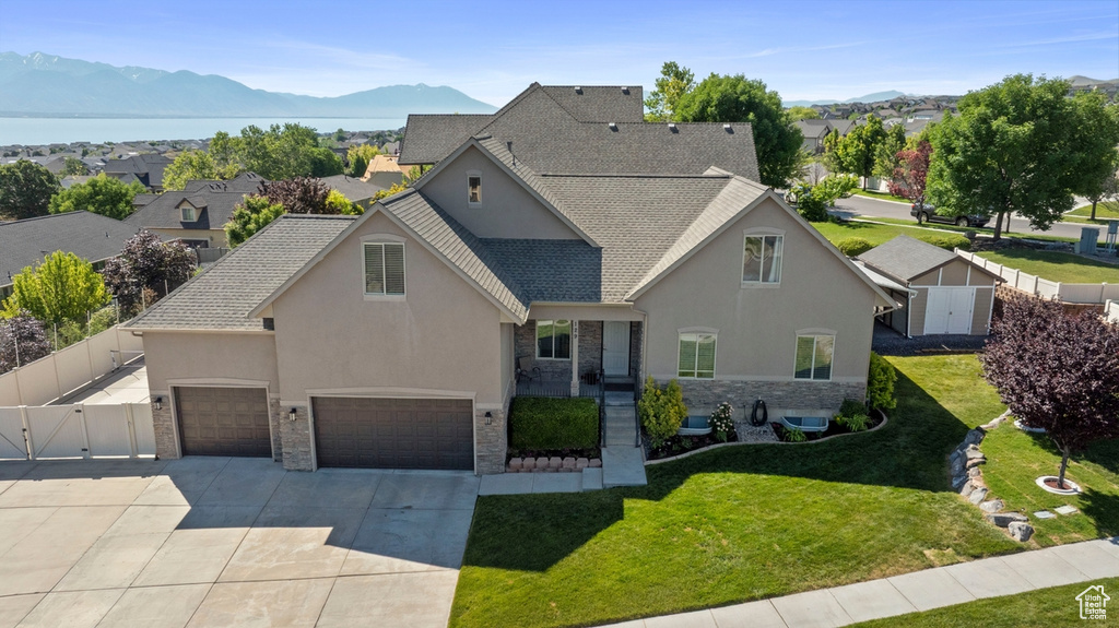 Traditional-style house with stone siding, stucco siding, concrete driveway, and a mountain view