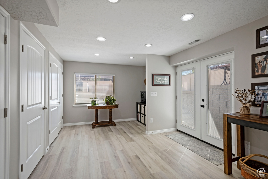 Entryway with light wood-style flooring, french doors, recessed lighting, and a textured ceiling