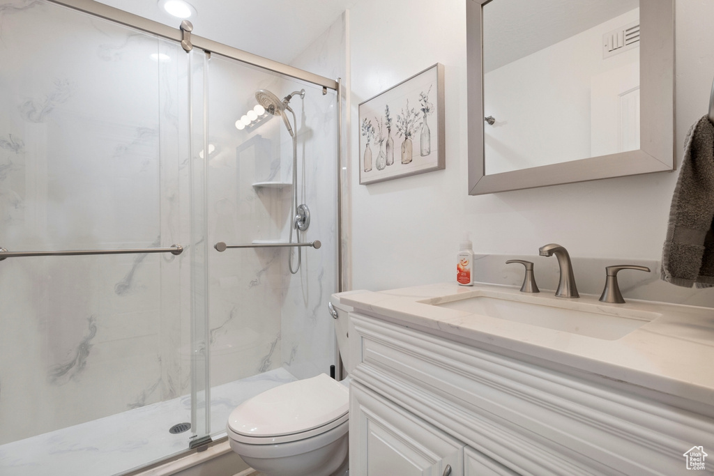 Full bath featuring vanity and a marble finish shower