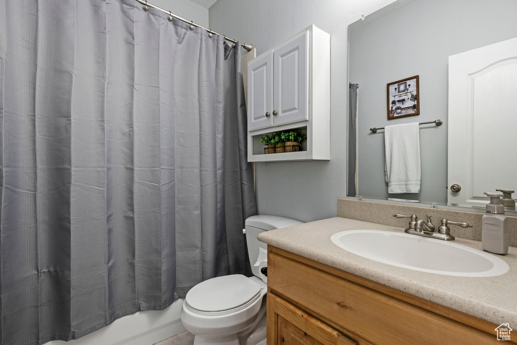 Bathroom with vanity and shower / tub combo with curtain