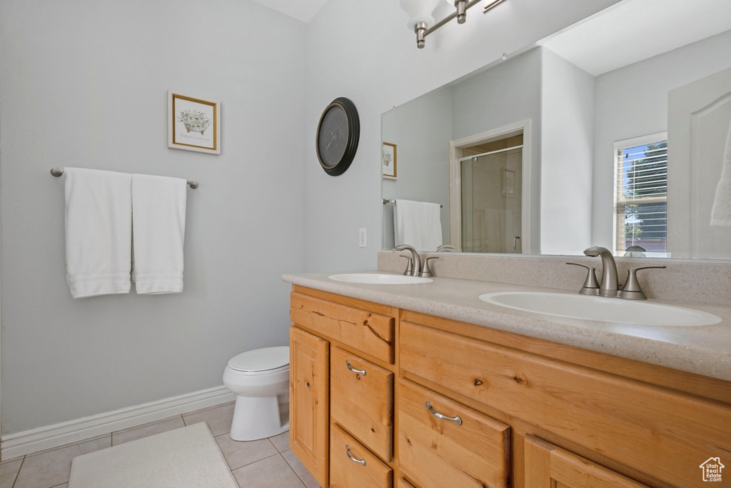 Bathroom with tile patterned floors, a stall shower, and double vanity