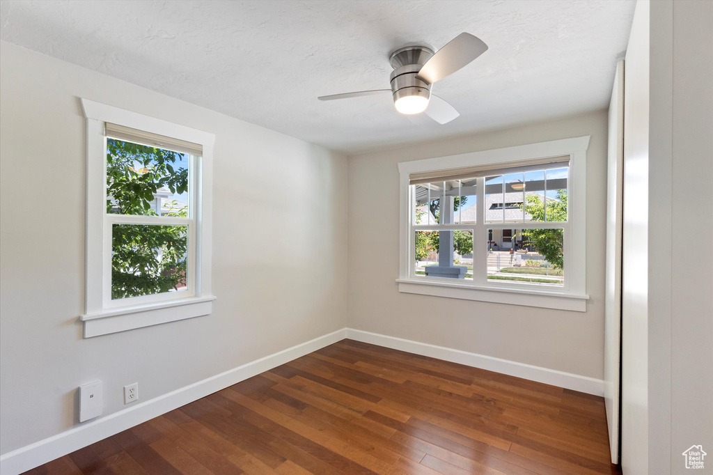 Unfurnished room with dark wood-style floors and ceiling fan