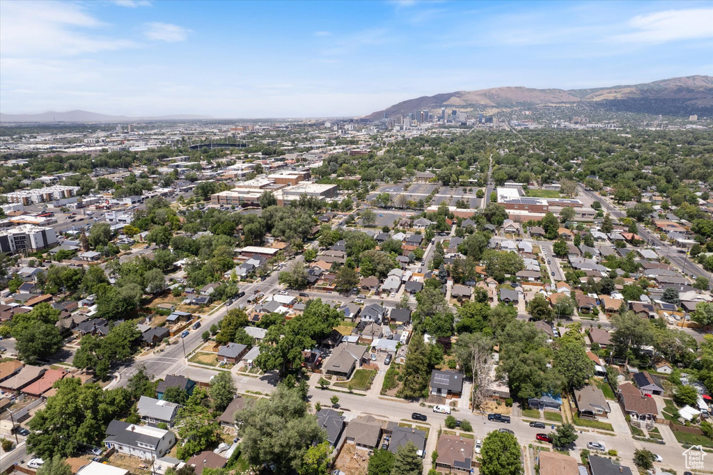 Aerial view of property and surrounding area with a mountainous background and nearby suburban area