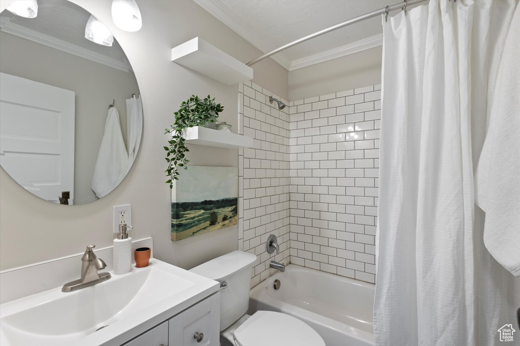 Full bathroom with vanity, ornamental molding, and shower / bath combo