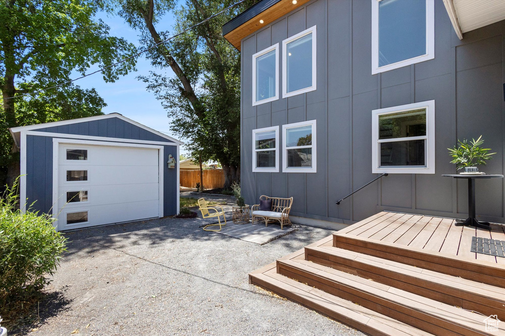 View of side of home with board and batten siding, an outbuilding, a garage, and driveway