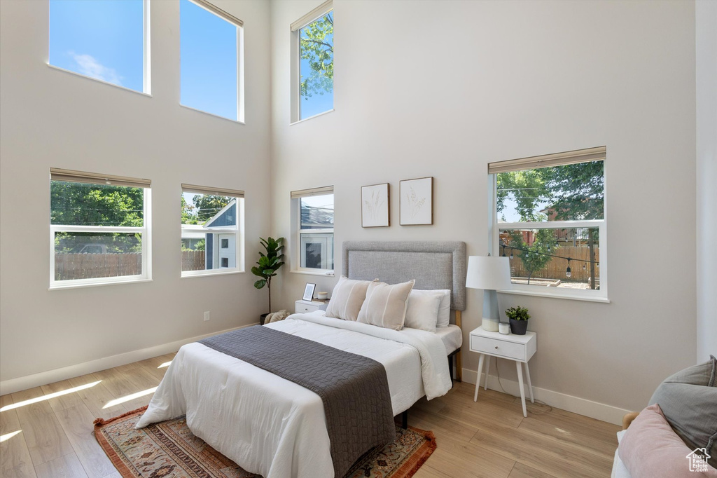 Bedroom featuring a towering ceiling and wood finished floors