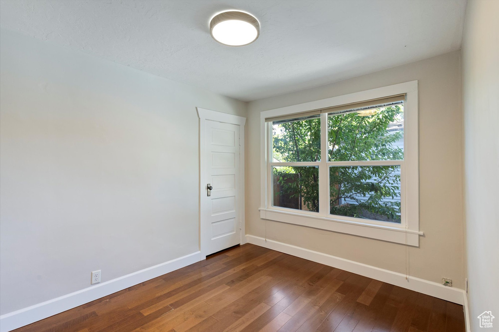 Spare room featuring dark wood-type flooring