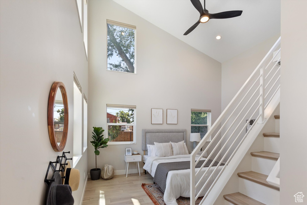 Bedroom featuring high vaulted ceiling, multiple windows, wood finished floors, recessed lighting, and ceiling fan