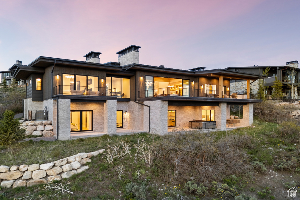 Back of property with a balcony and a chimney