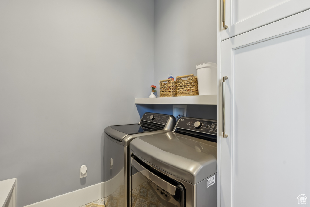 Laundry room featuring washer and clothes dryer and cabinet space