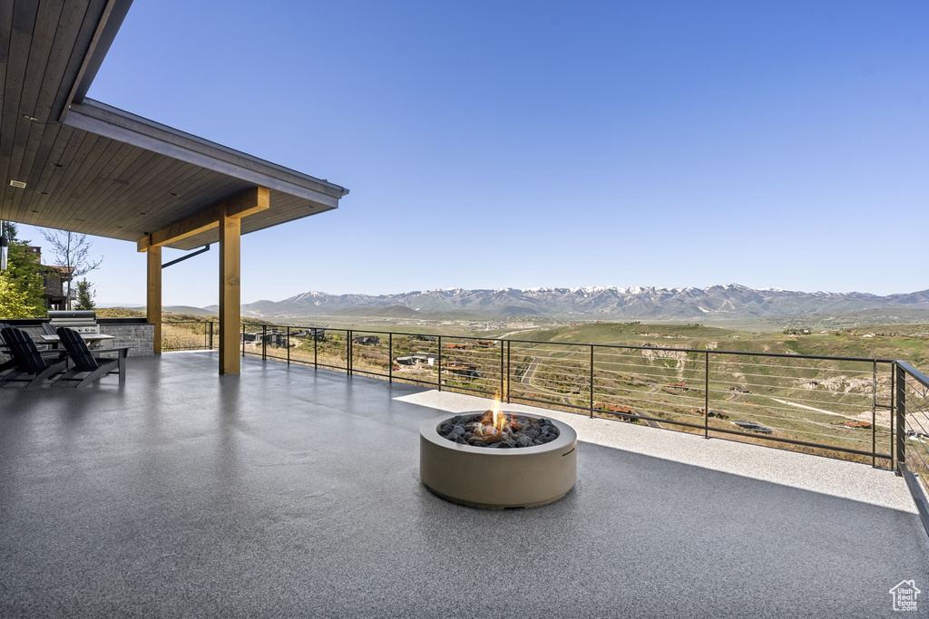 View of patio featuring a mountain view, a fire pit, and a rural view
