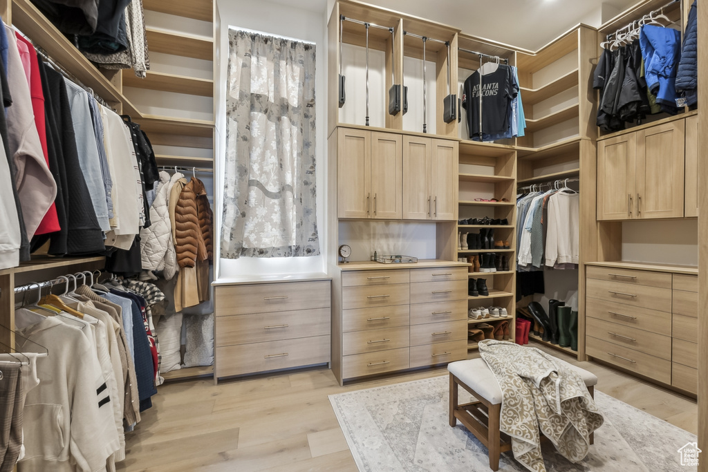 Walk in closet with light wood-style flooring