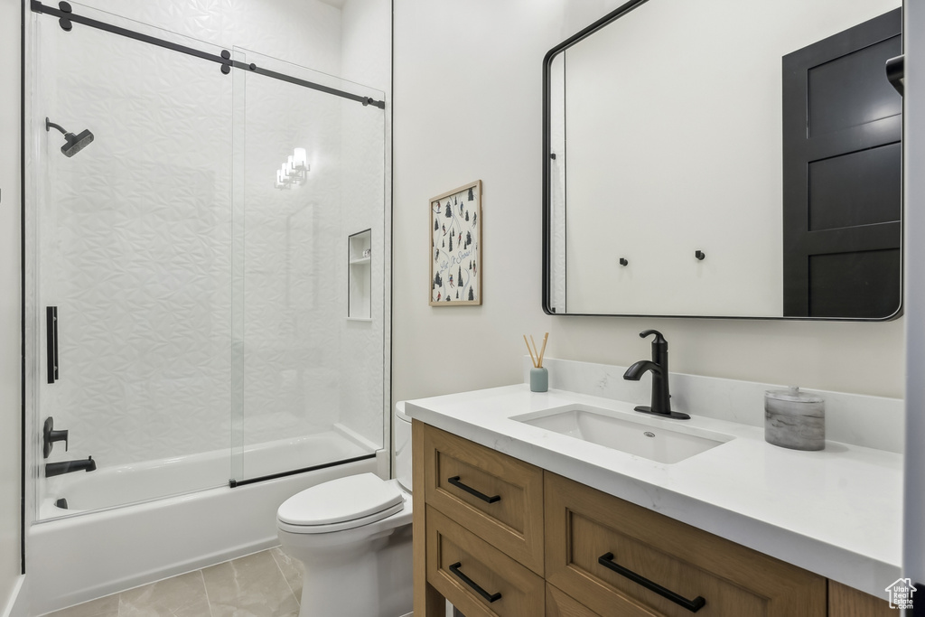 Bathroom featuring vanity and shower / bath combination with glass door