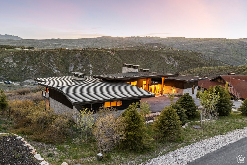 Property exterior at dusk with a mountain view and a chimney