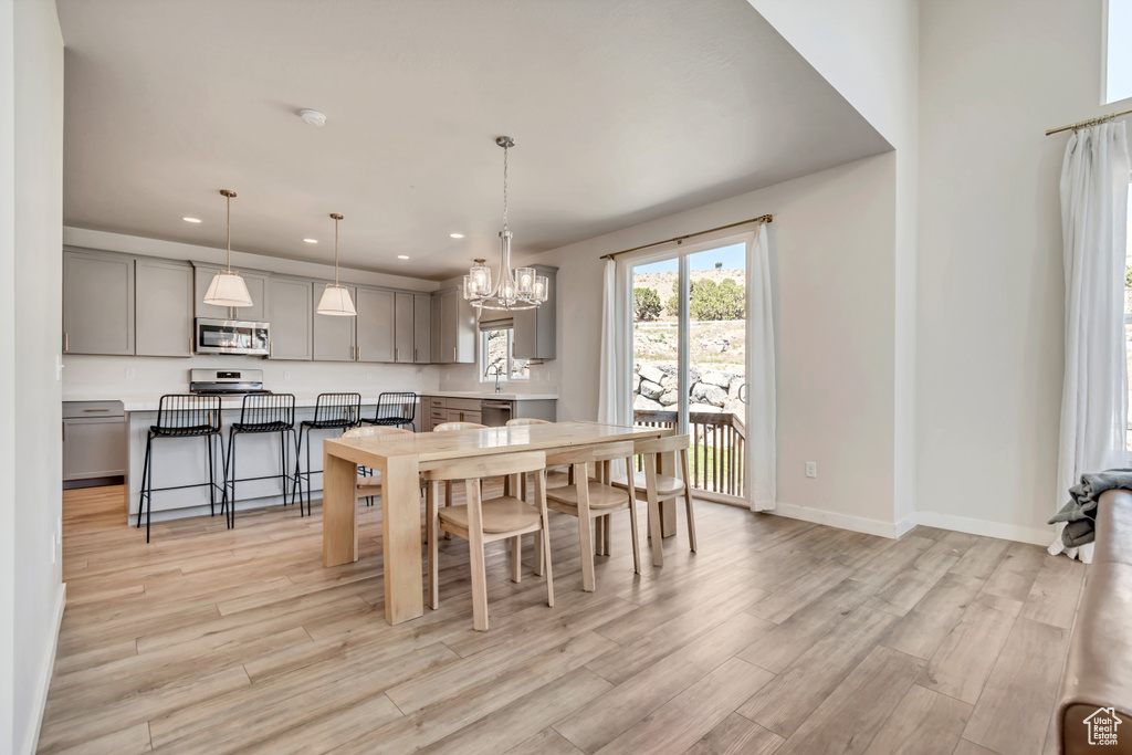 Dining room with recessed lighting, a chandelier, light wood-type flooring, and baseboards
