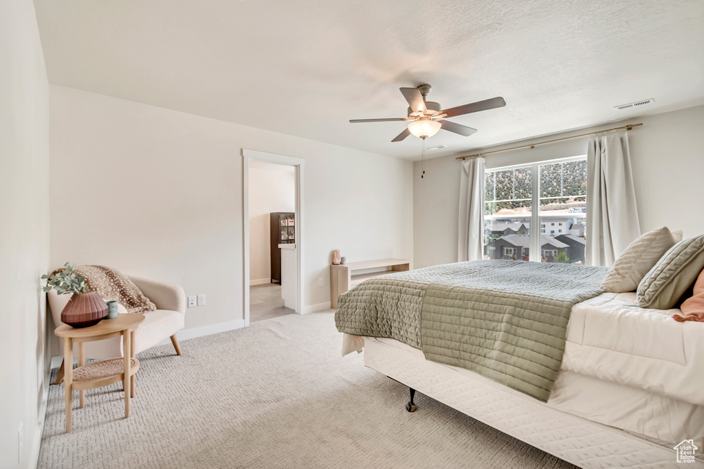 Bedroom featuring baseboards, light carpet, and ceiling fan