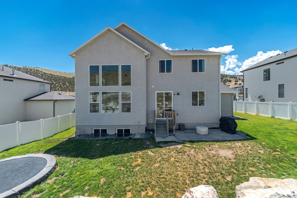 Back of property with stucco siding and a patio