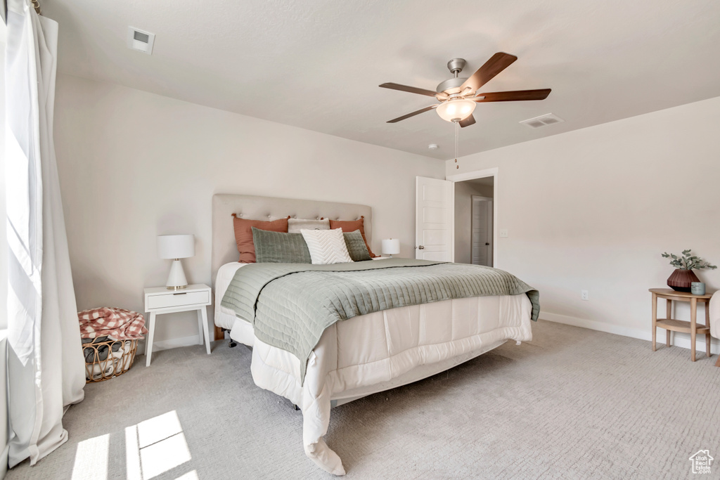 Bedroom featuring light carpet, ceiling fan, and baseboards