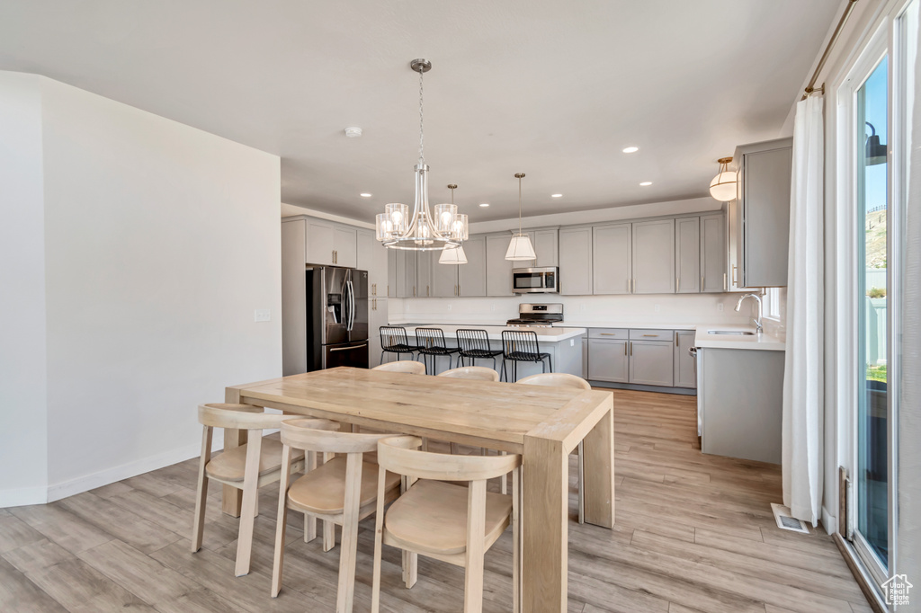 Dining area featuring recessed lighting, light wood-style flooring, a chandelier, and baseboards