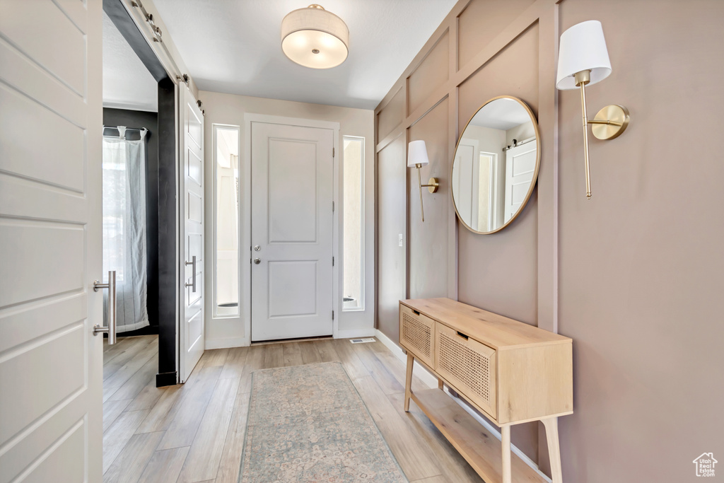 Entryway with light wood finished floors and baseboards