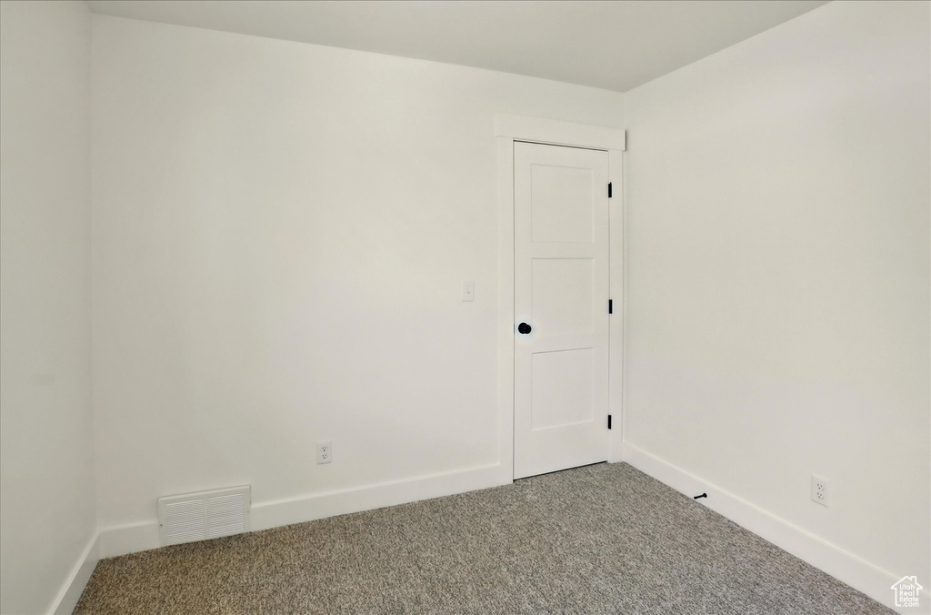 Carpeted spare room with baseboards