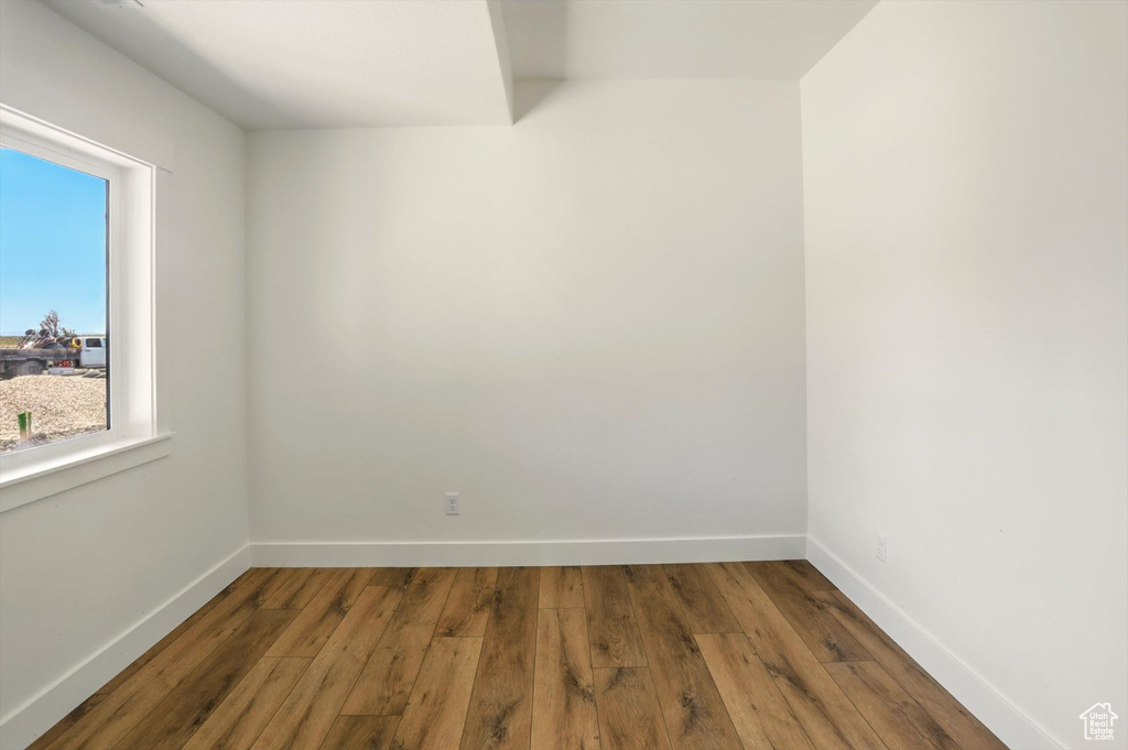 Empty room with hardwood / wood-style flooring and baseboards
