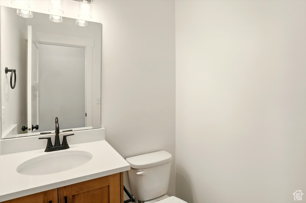 Half bathroom with toilet and vanity